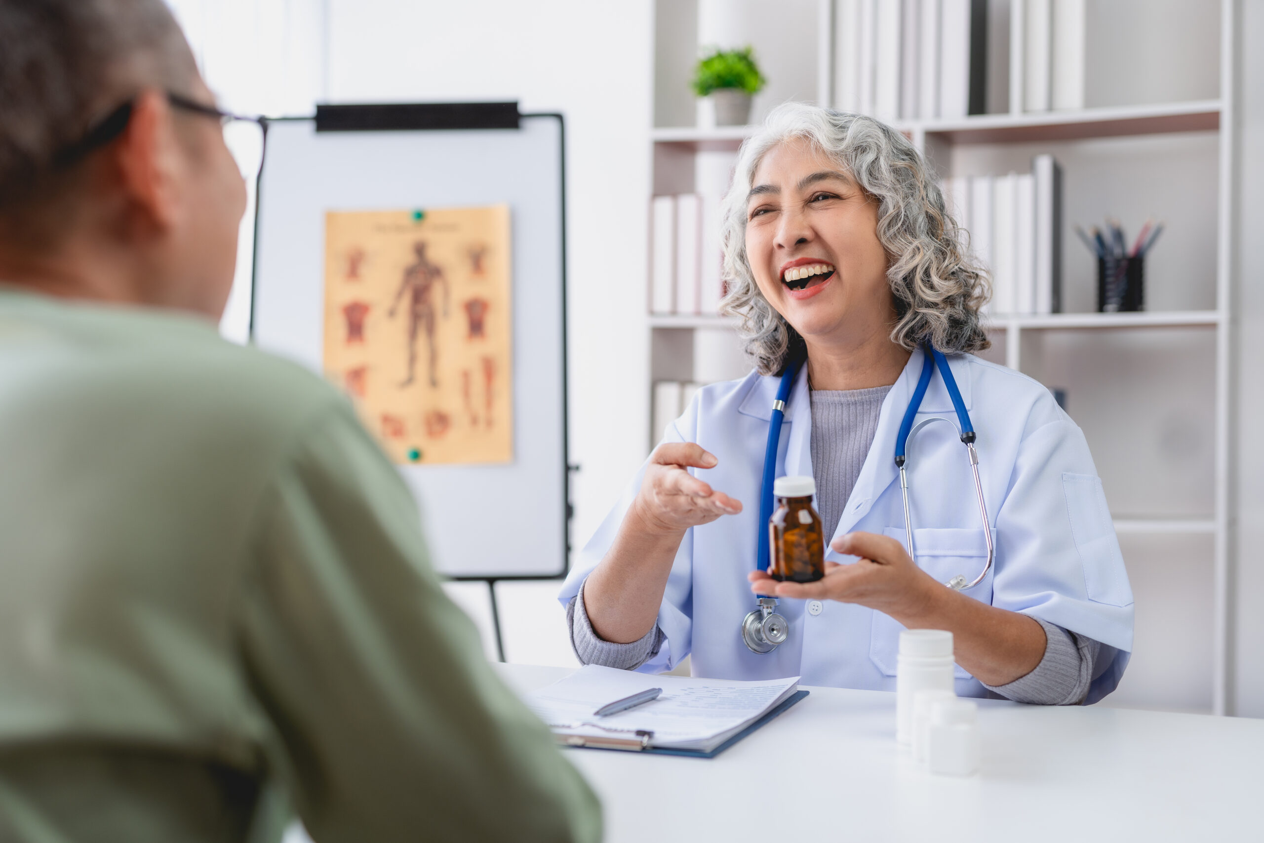 cheerful doctor explaining medication to a patient with a smile, ensuring understanding and care in the medical office.